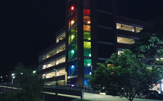 Photo of a parking garage with levels lit with colors of the rainbow