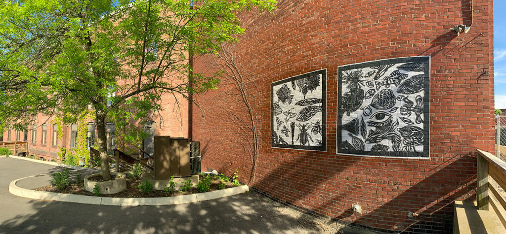 Black and white murals on a brick building